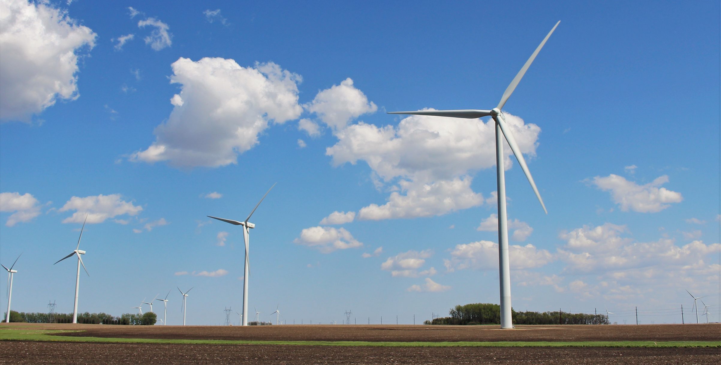 A group of wind turbines in the countryside.